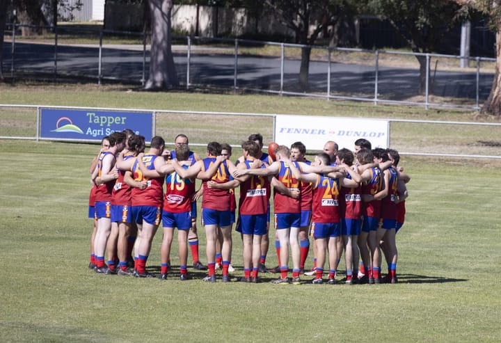 Lions AFL win the battle in the mud to take first spot on the ladder